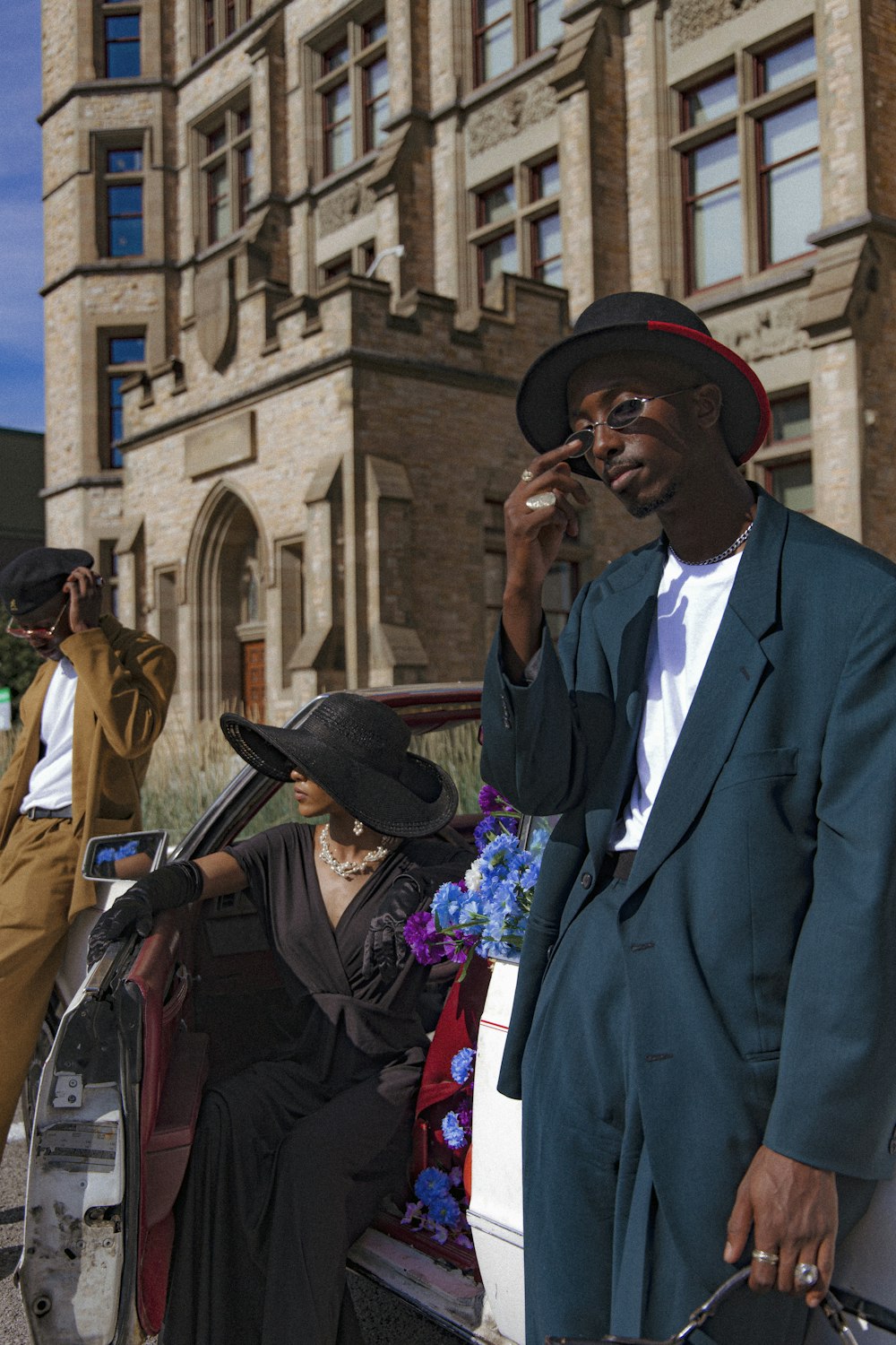 a man in a suit and hat talking on a cell phone