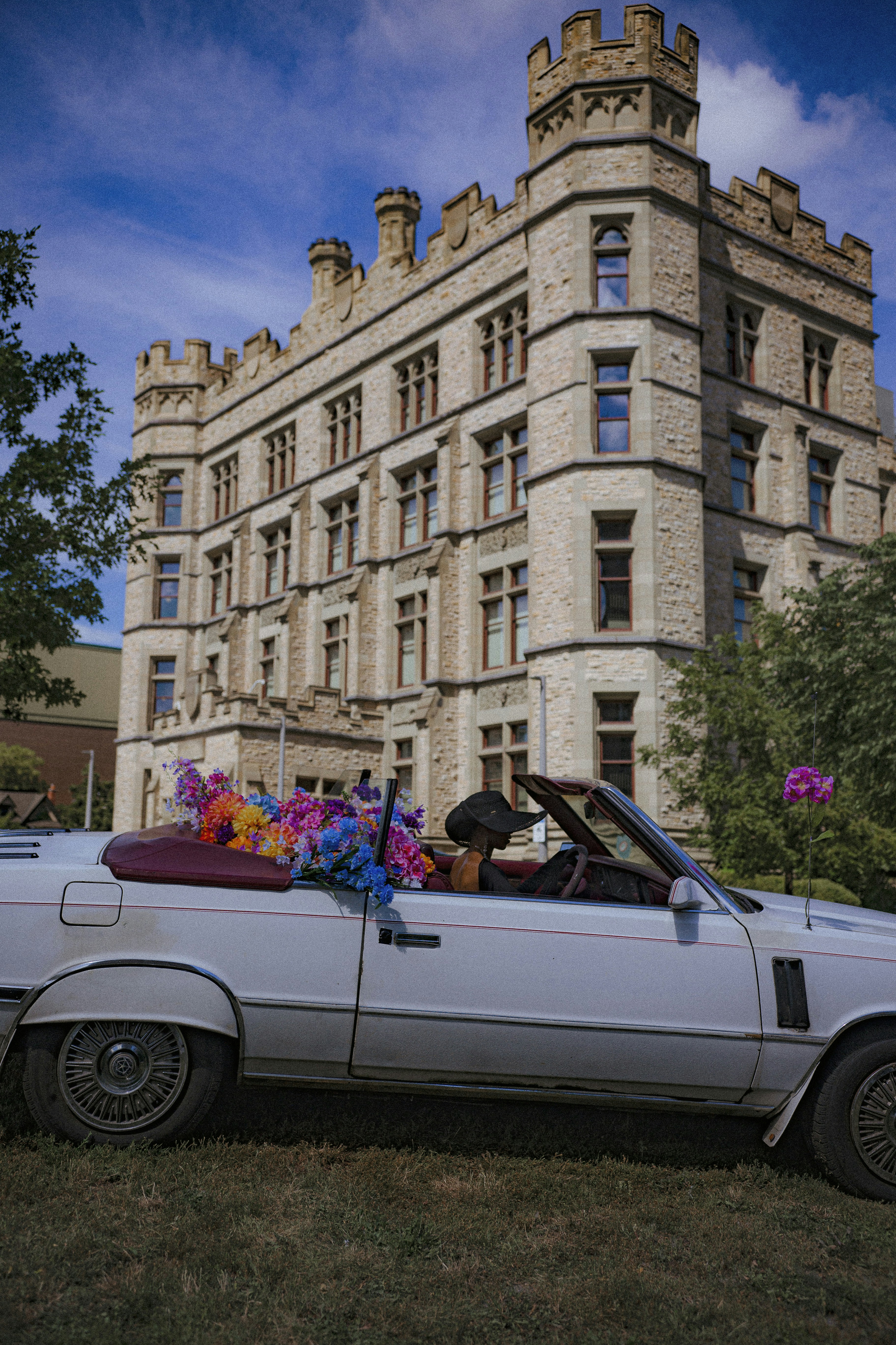 a white car parked in front of a tall building