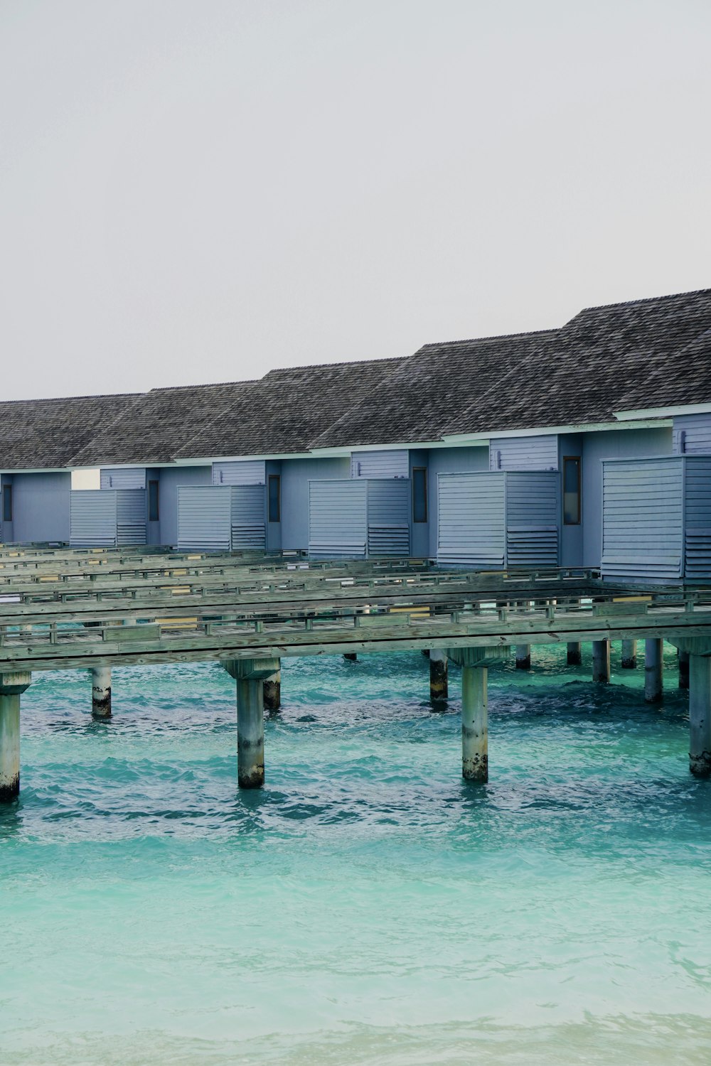 a row of beach huts sitting on top of a pier