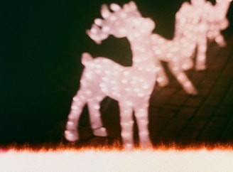 A whimsical North Pole scene with Santa’s sleigh and reindeer under a starlit sky, glowing softly in red and green hues.