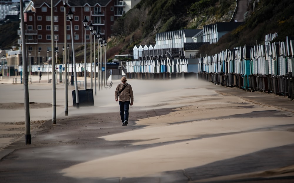 a person walking down a street next to a row of houses