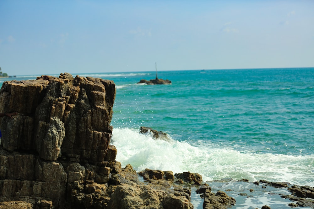 a person standing on a rock near the ocean