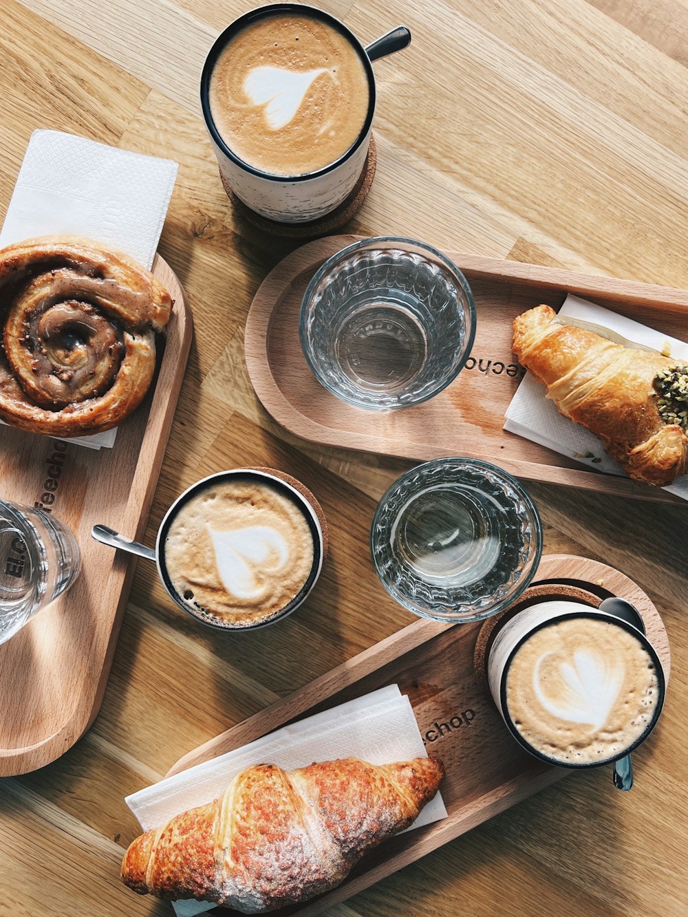 a wooden table topped with pastries and drinks