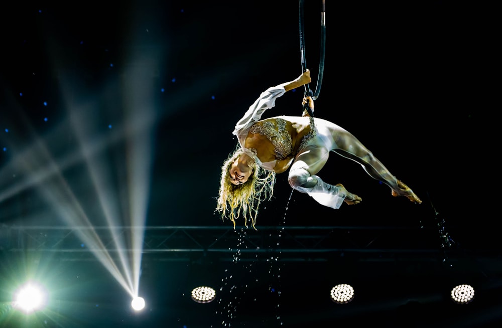 a woman is performing on a pole in the air