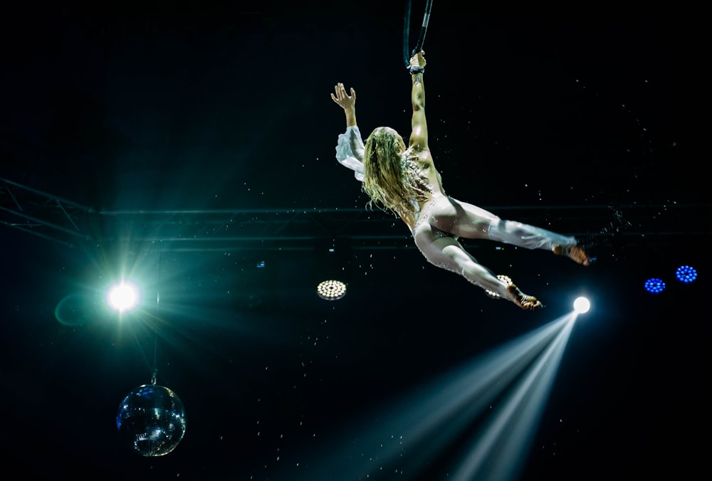 a woman is suspended in the air on a rope