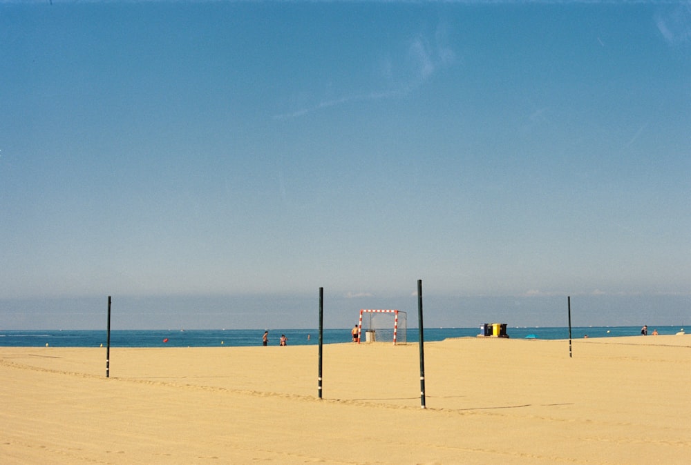 a sandy beach with a volleyball court and a blue sky