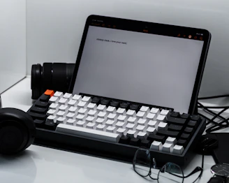 A clean workspace with a laptop displaying a typing test and a numeric keypad beside it.