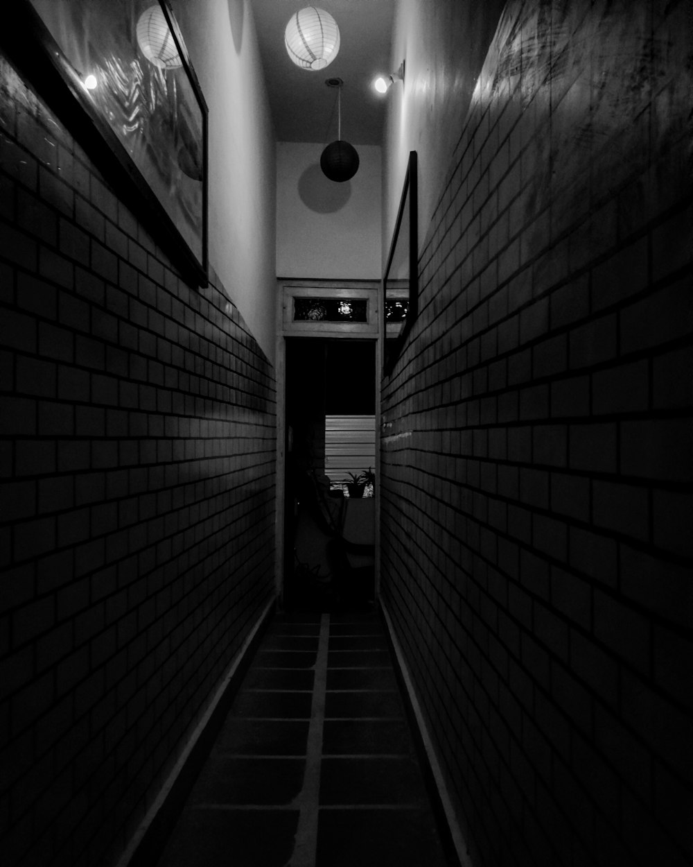 a dark hallway with a light hanging from the ceiling