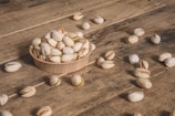 a wooden bowl filled with nuts on top of a wooden table