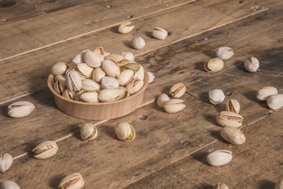 a wooden bowl filled with nuts on top of a wooden table