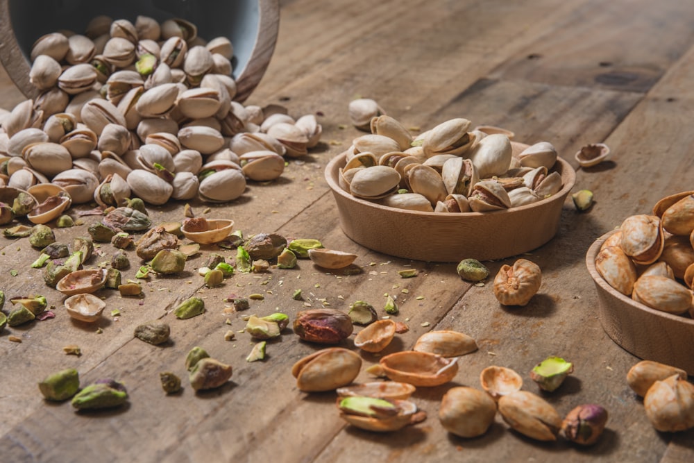 a wooden table topped with bowls filled with nuts