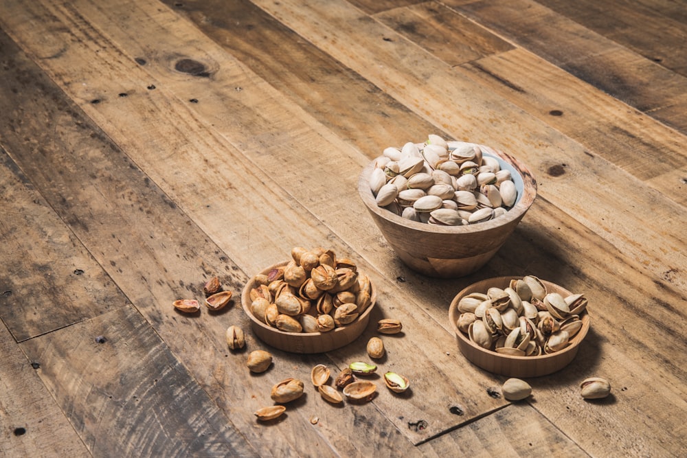 a wooden table topped with bowls filled with nuts