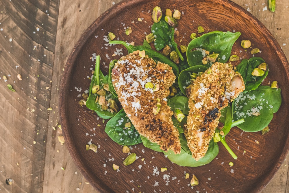 a wooden plate topped with chicken and spinach