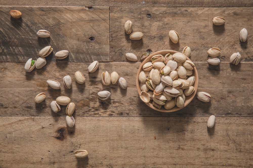 a bowl filled with nuts on top of a wooden table