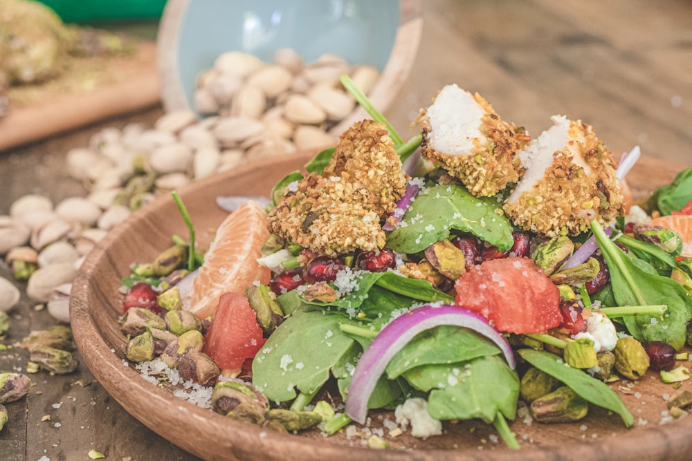 a wooden bowl filled with a salad on top of a table