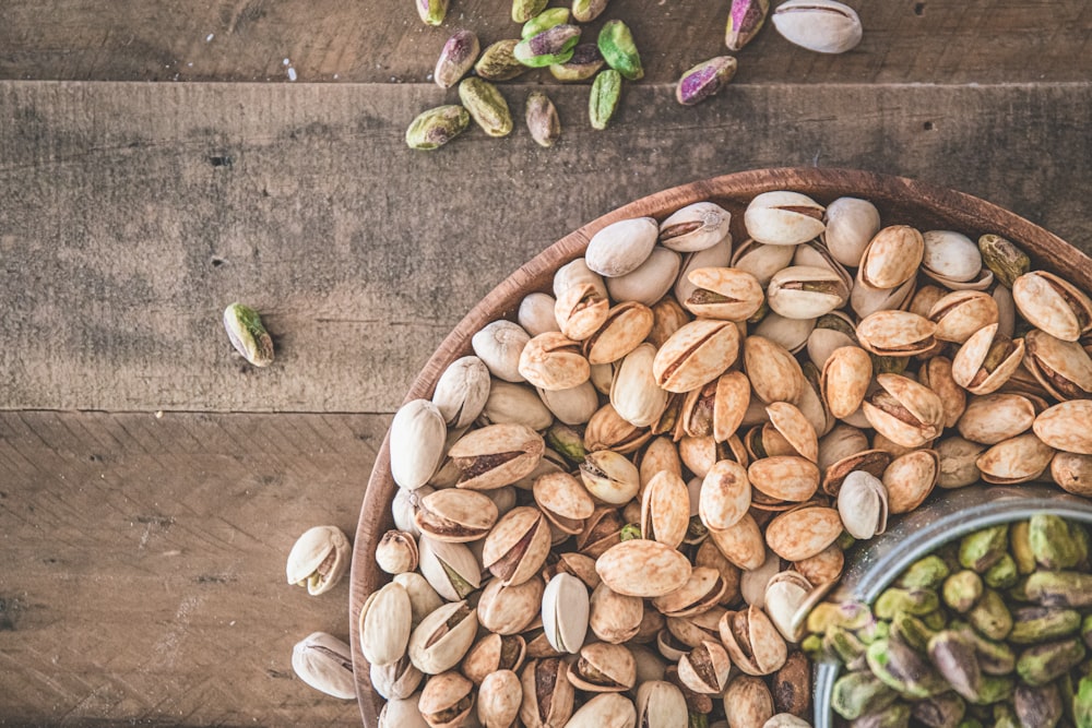 a wooden bowl filled with nuts on top of a table