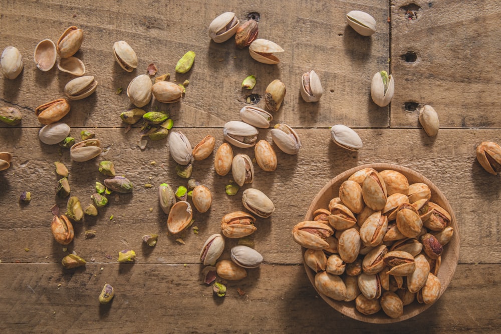 a wooden bowl filled with nuts on top of a table