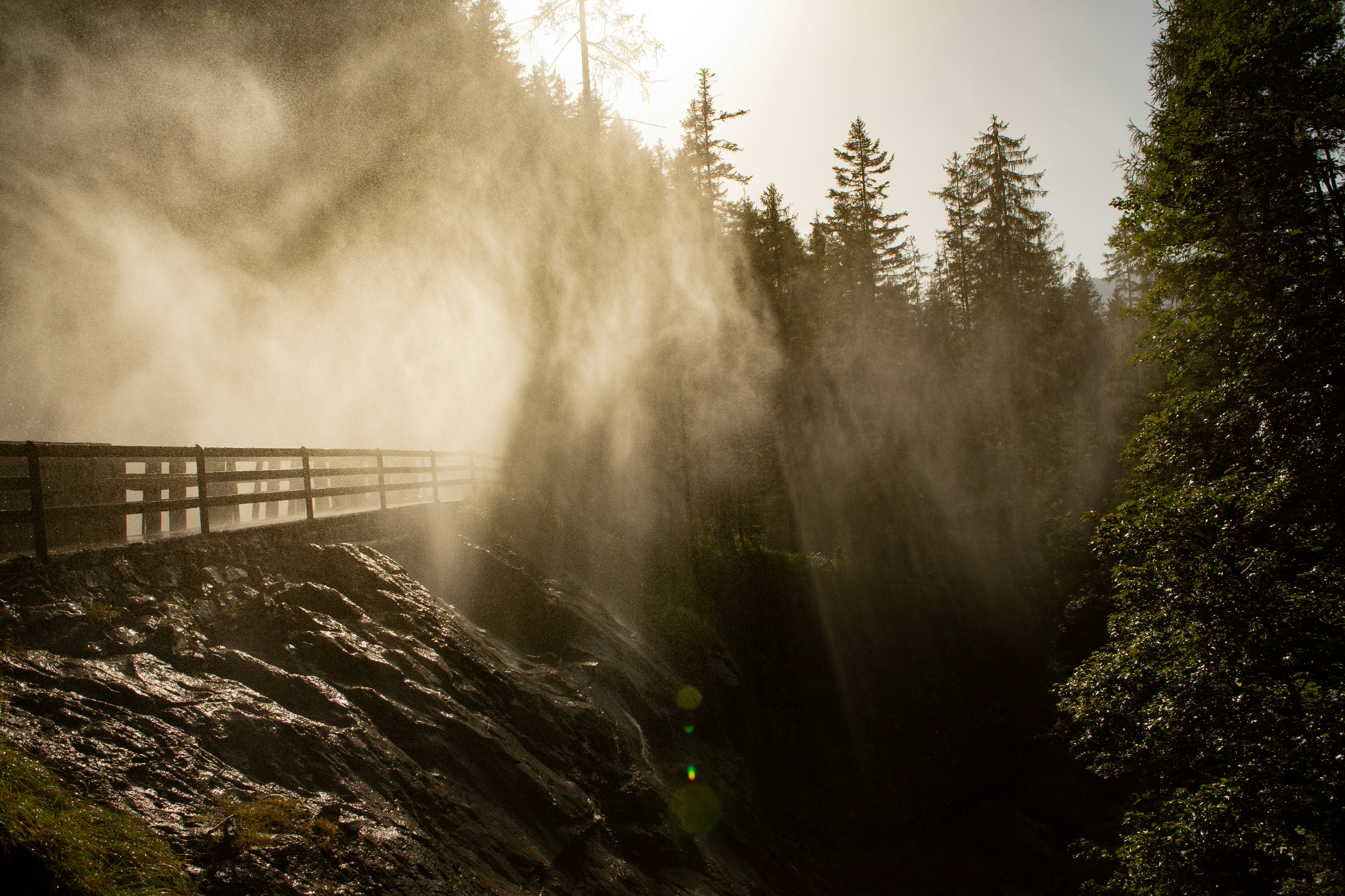 the sun shines through the mist on a bridge