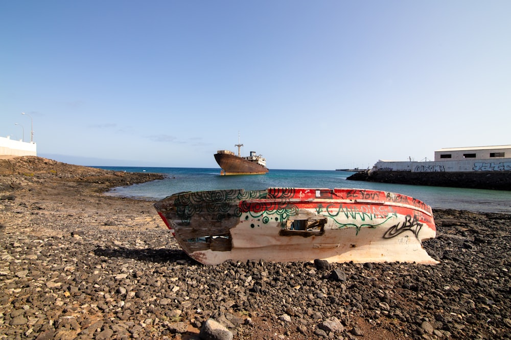 a boat sitting on top of a rocky beach