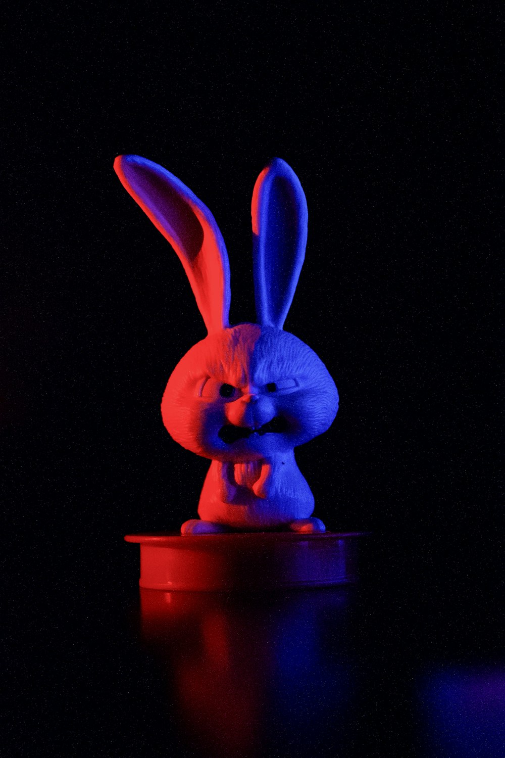 a blue and red rabbit statue sitting on top of a table
