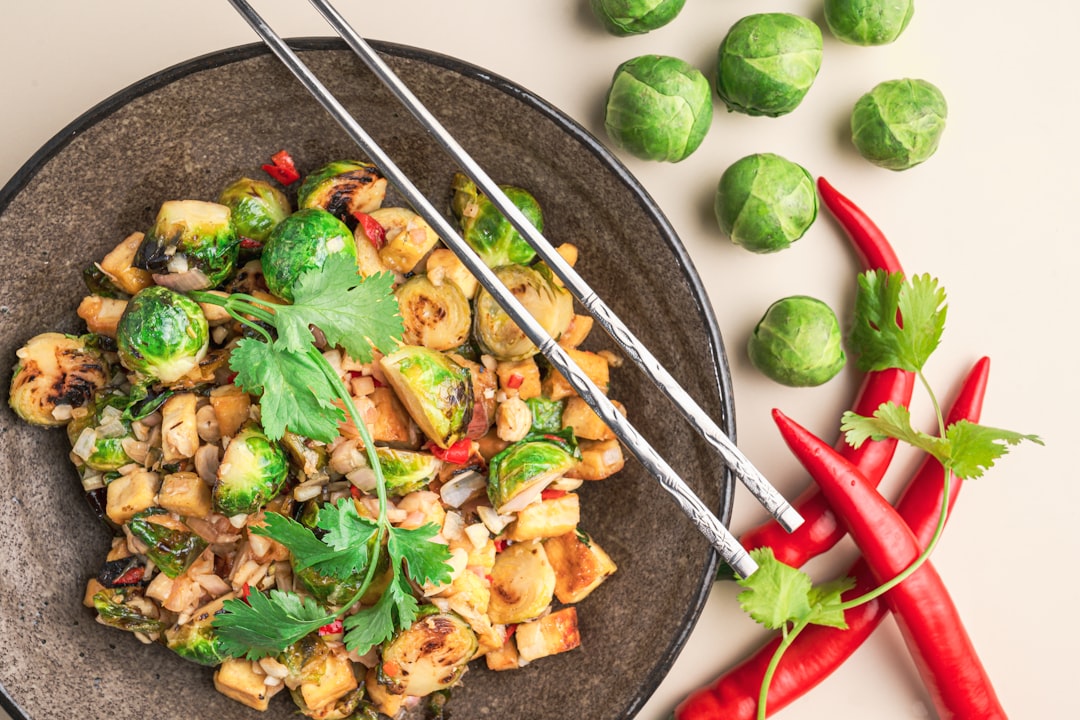 a plate of food with chopsticks and vegetables,