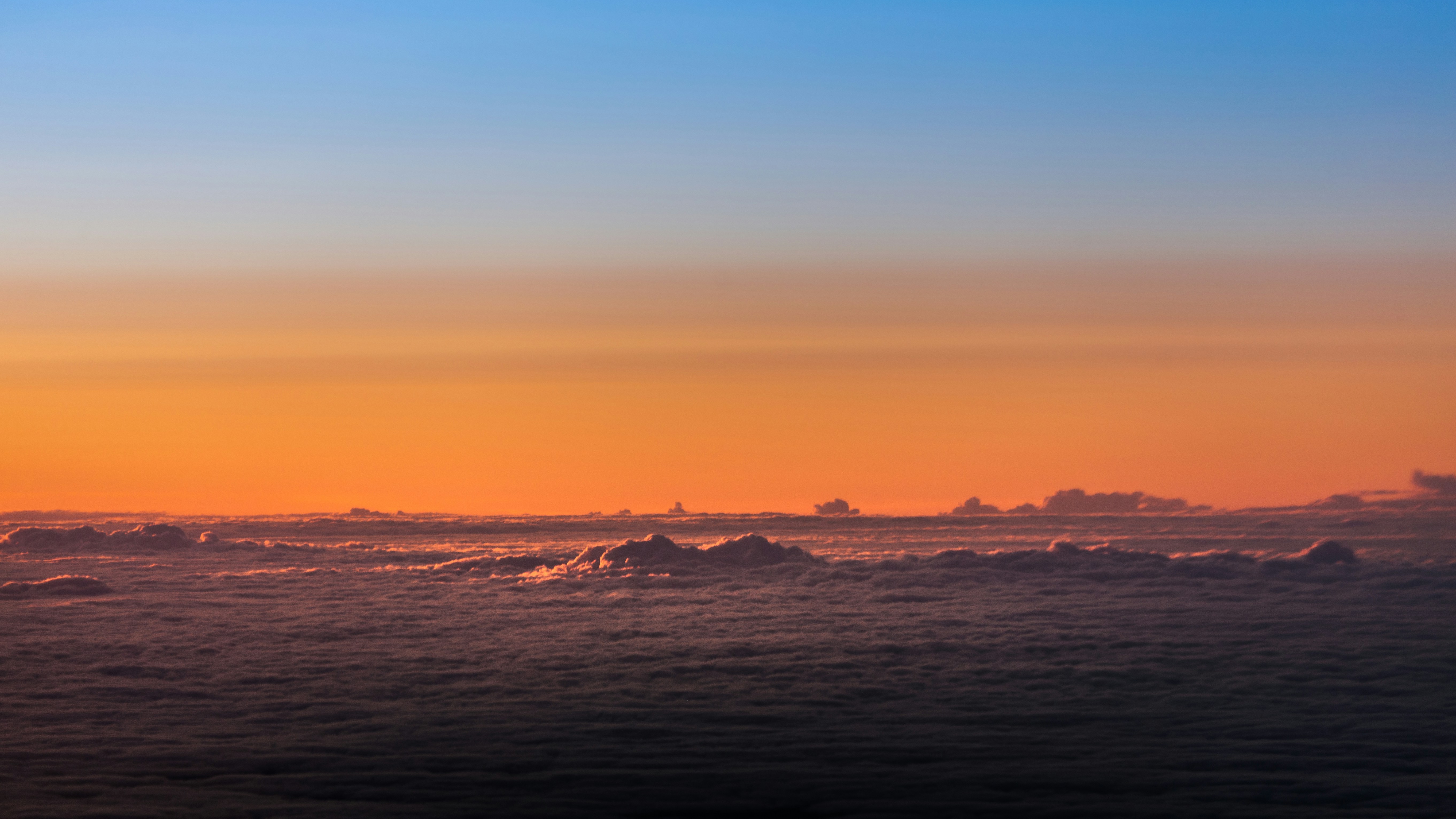 the sun is setting over the ocean with icebergs in the foreground