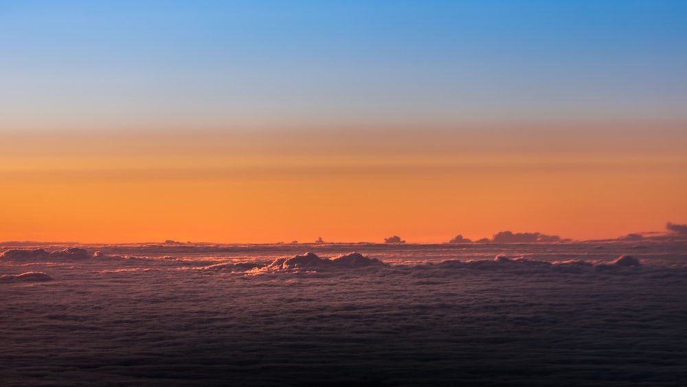 太陽が海に沈み、前景に氷山がある