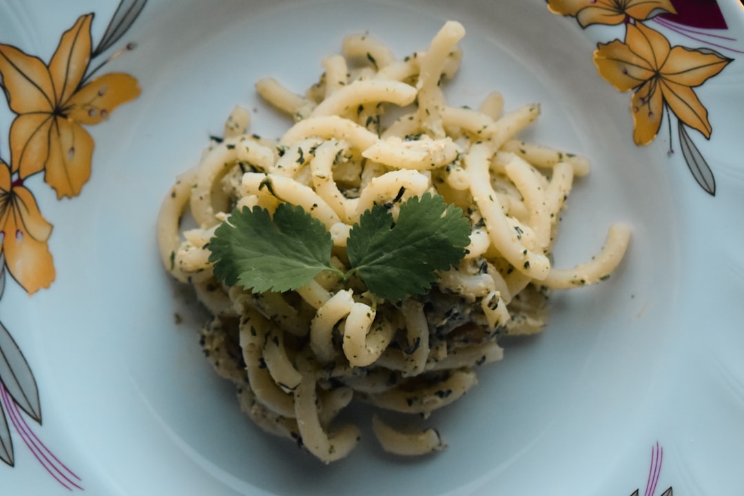 a plate of pasta with parsley on top of it,