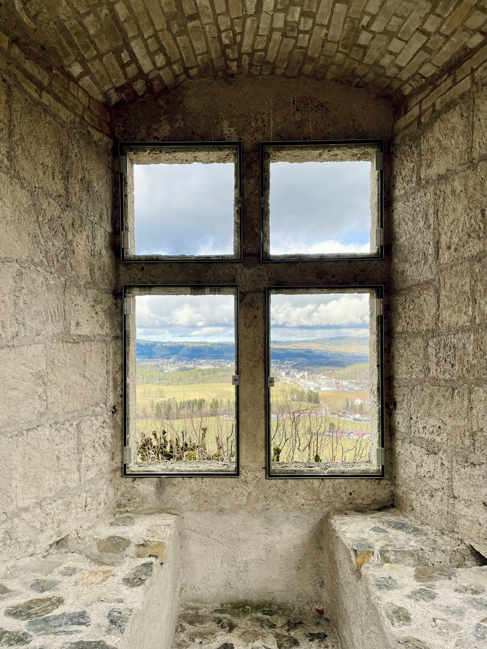 una finestra in un edificio in pietra con una panchina di fronte ad essa
