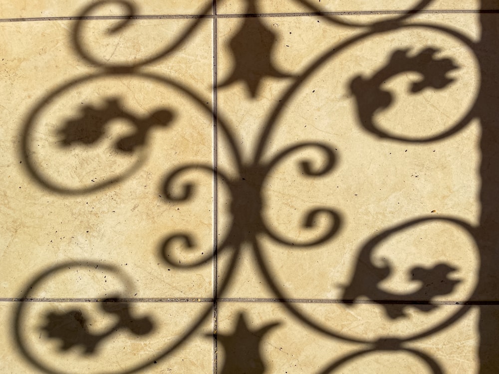 a shadow of a bird on a tile wall