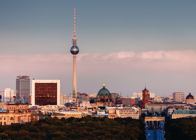 A striking aerial shot of Berlin's cityscape at dawn, with sharp contrasts between urban structures and green spaces.