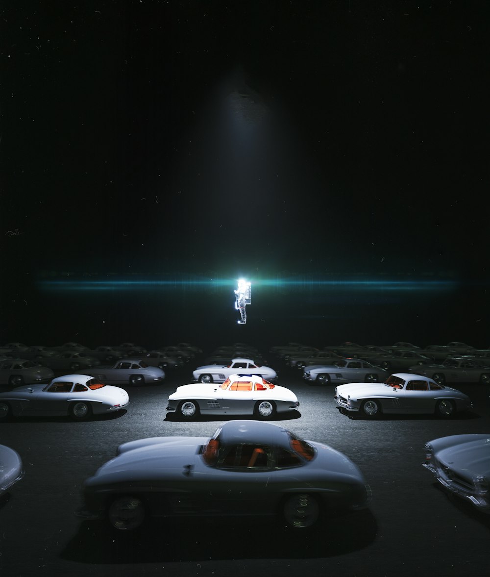 a group of cars parked in a parking lot at night