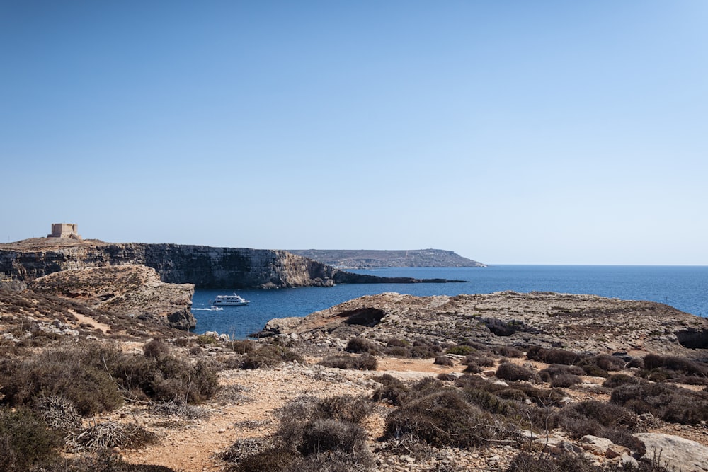 a boat is in the water near a rocky cliff