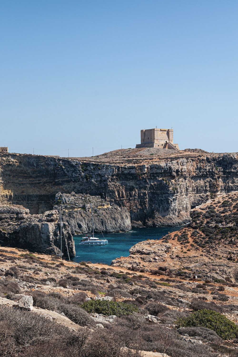 a rocky cliff with a body of water in front of it