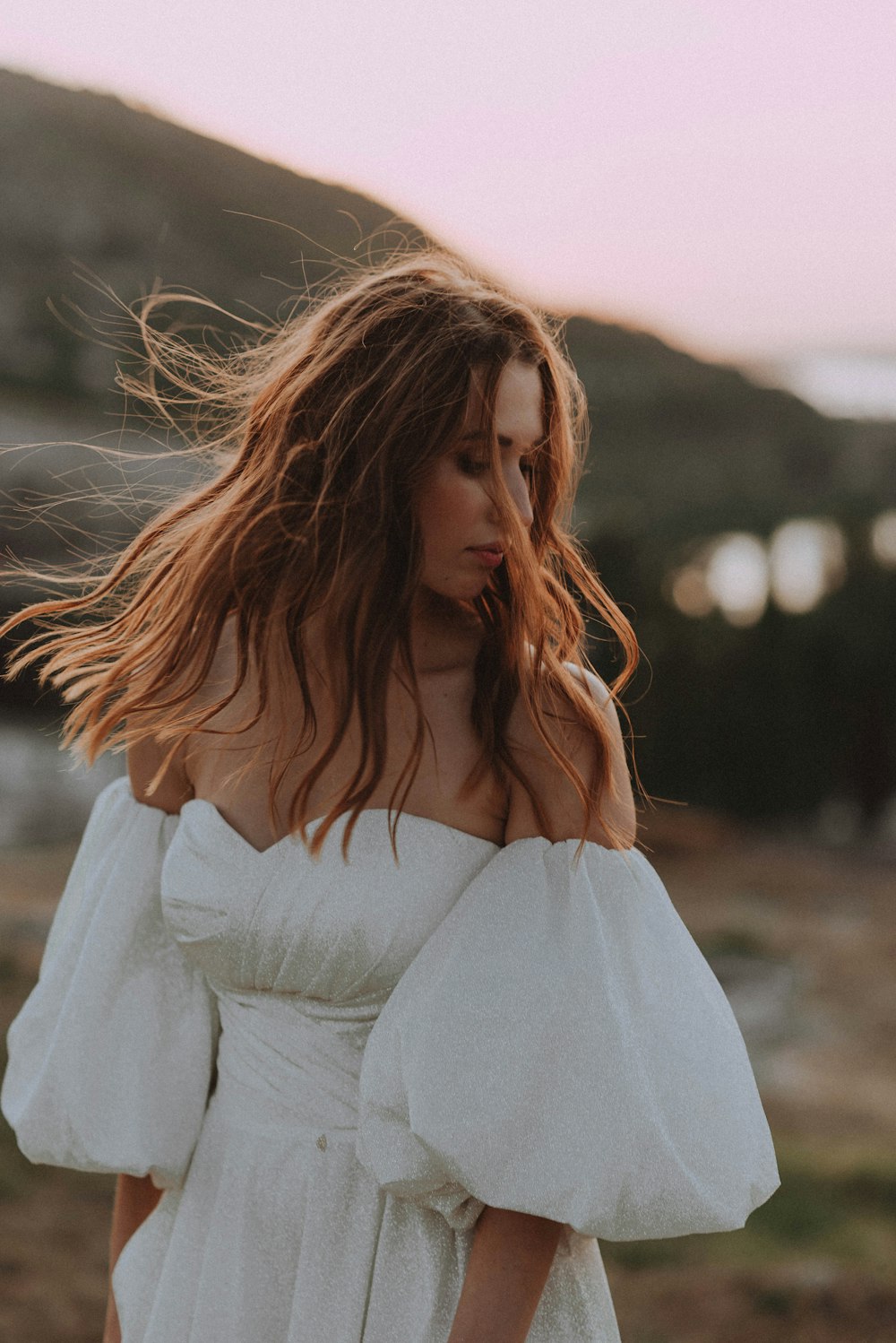 a woman in a white dress standing on a beach