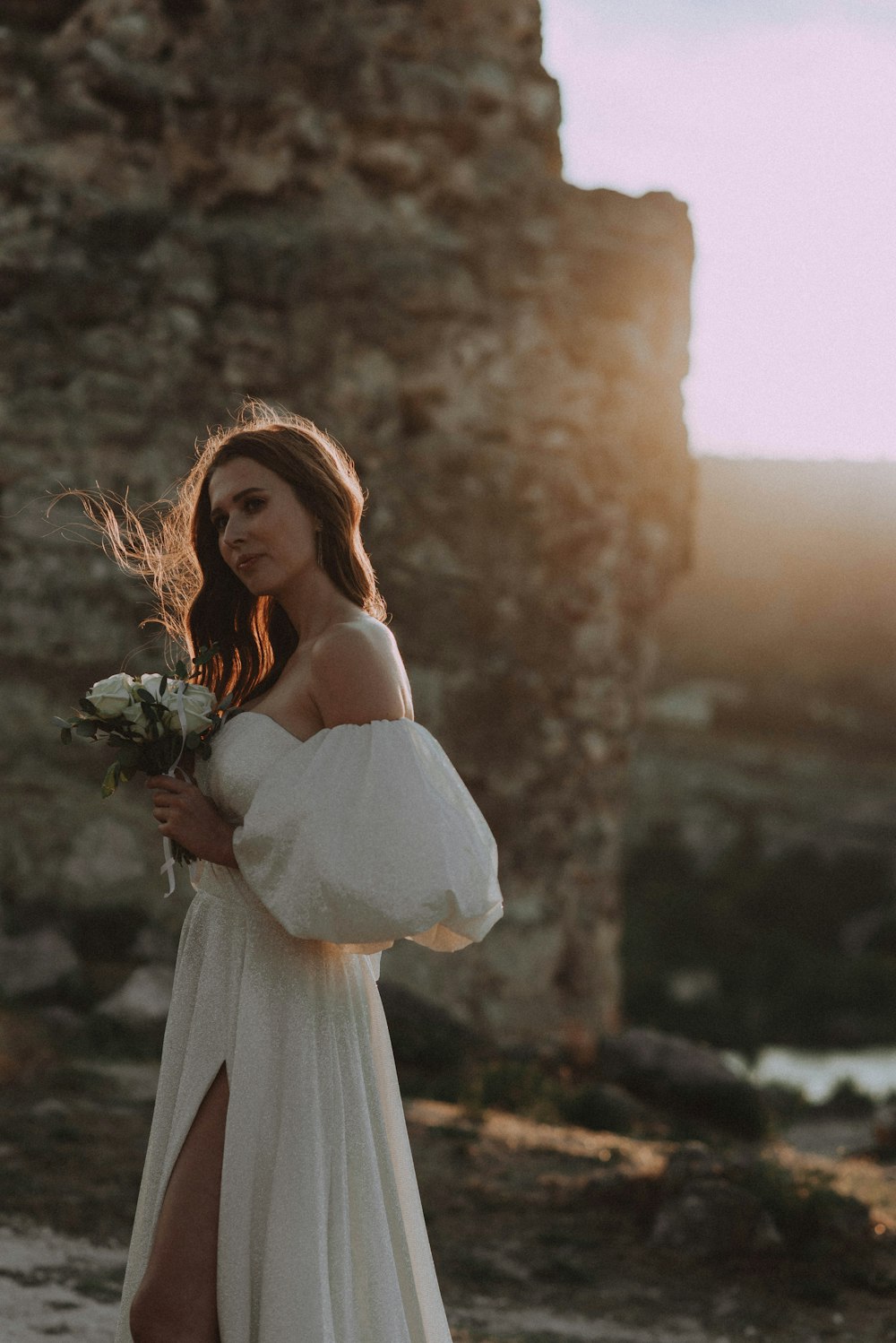 a woman in a white dress holding a bouquet of flowers