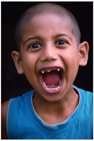 a young boy with a toothbrush in his mouth