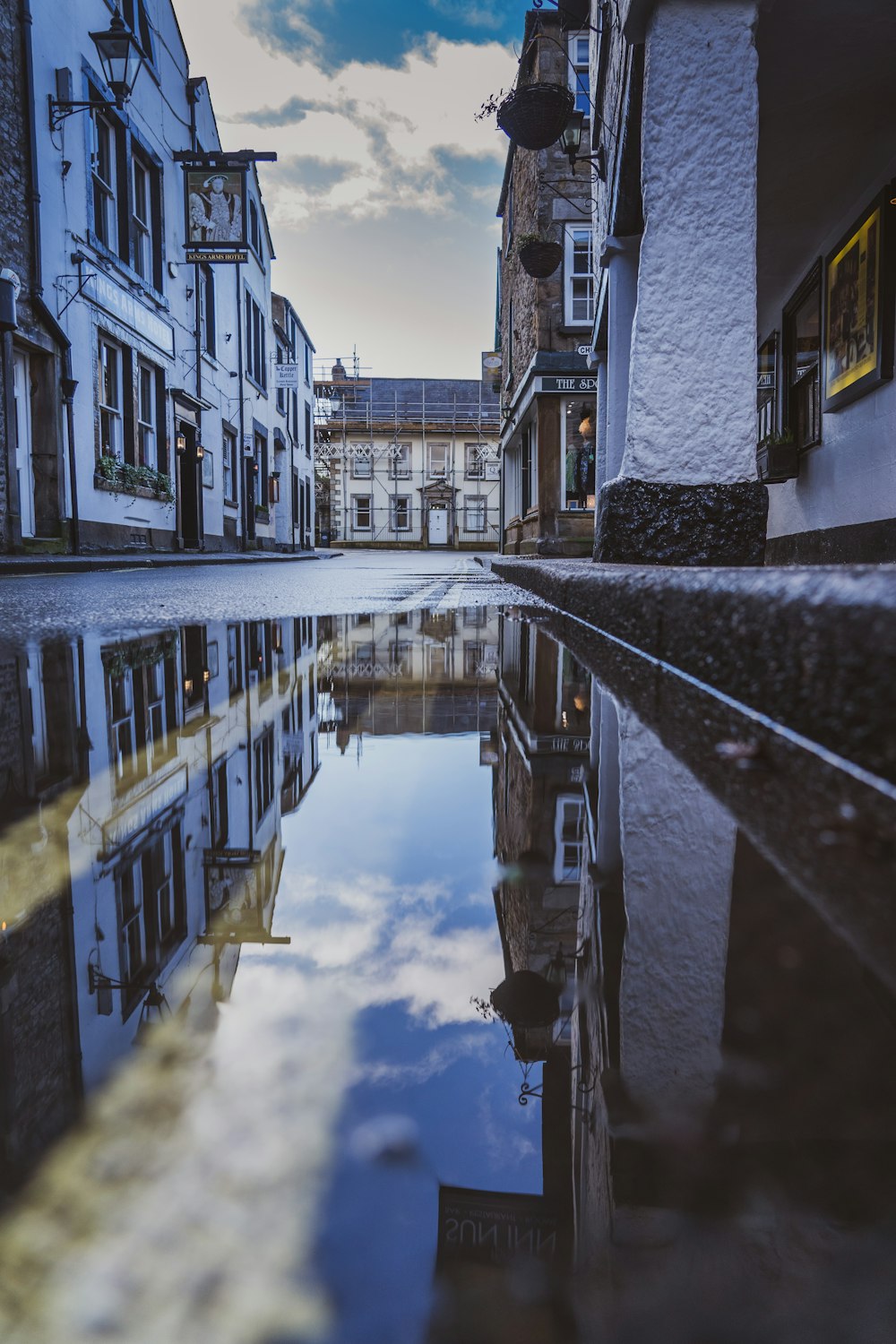 a reflection of buildings in a puddle of water