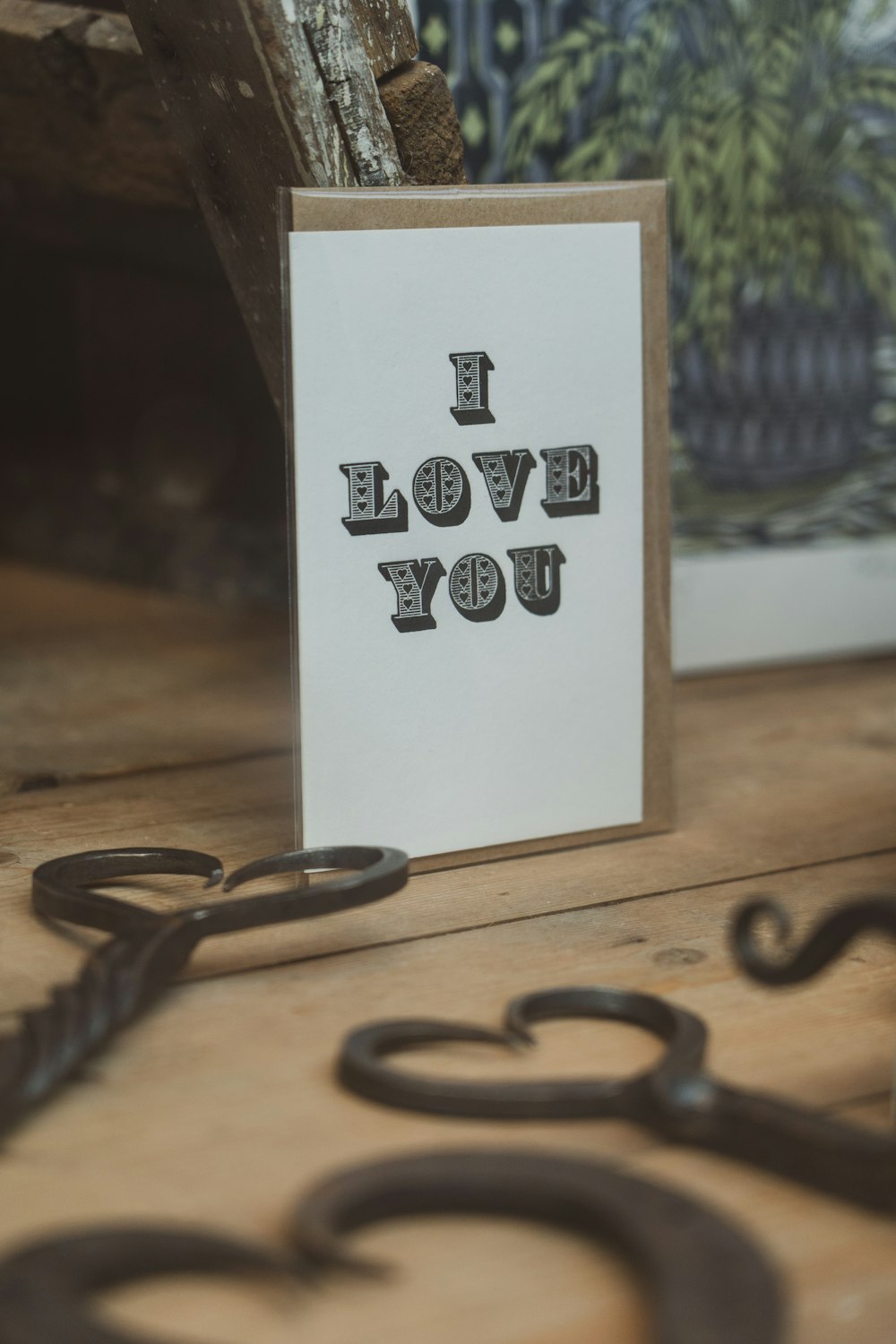 a card that says i love you with a pair of scissors