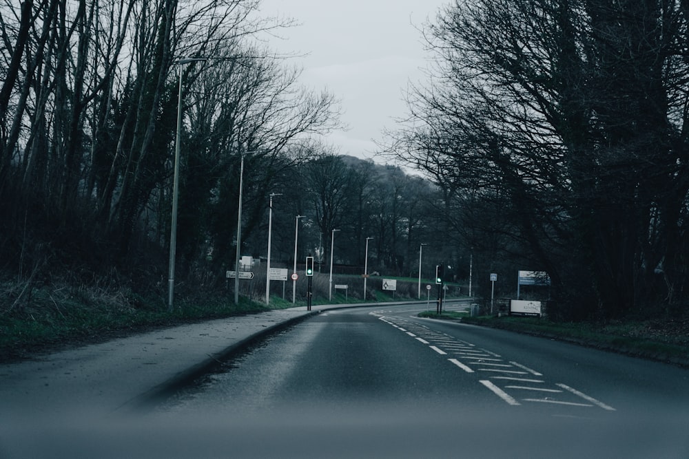 an empty road with trees on both sides