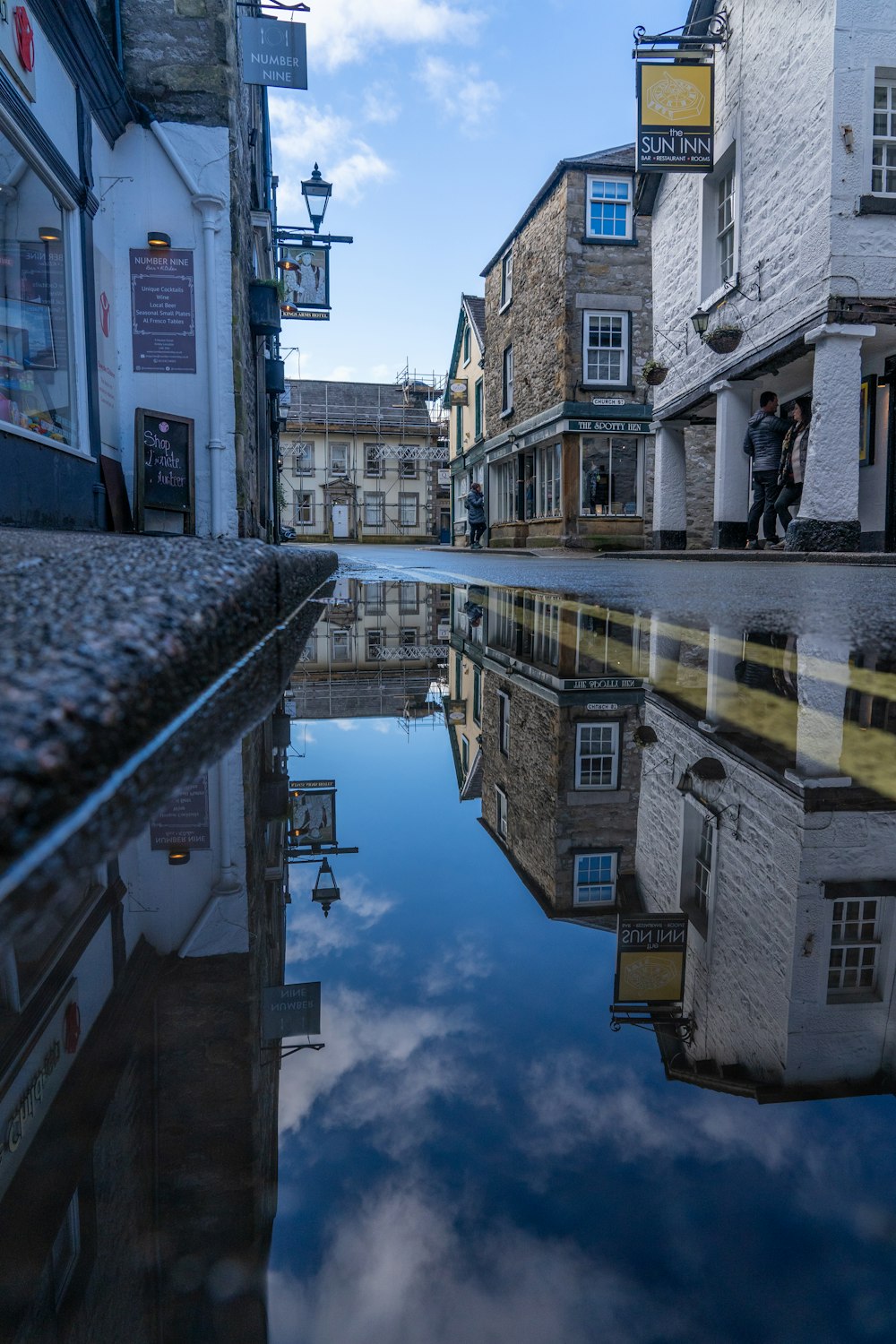 a reflection of buildings in a puddle of water