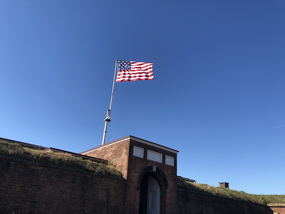 uma bandeira americana voando sobre um edifício de tijolos