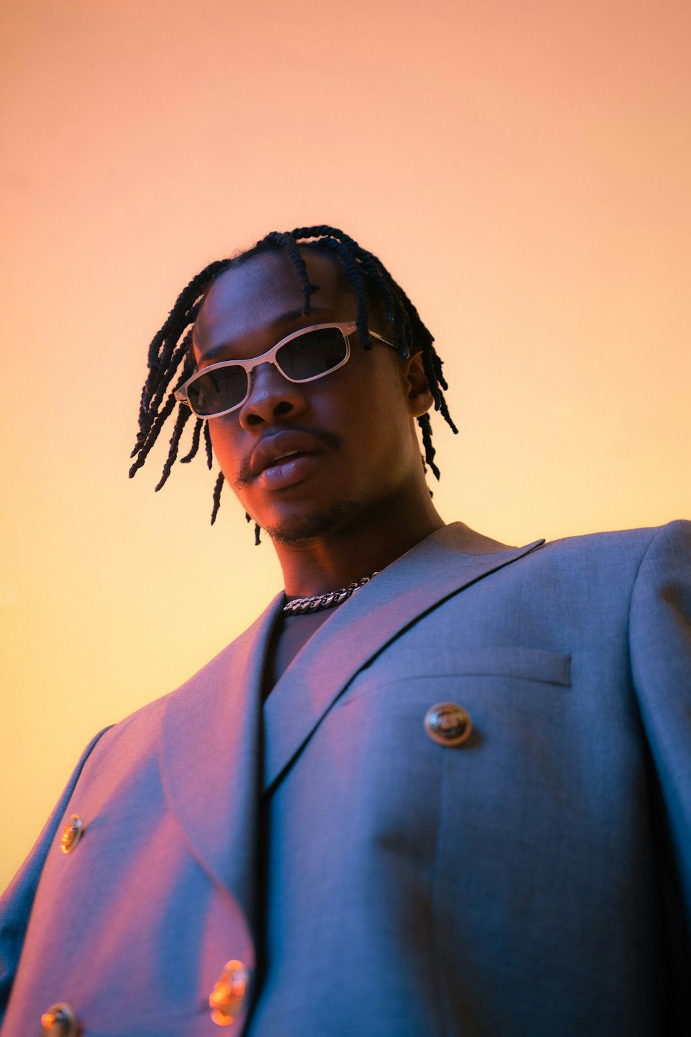 a man with dreadlocks wearing a suit and sunglasses