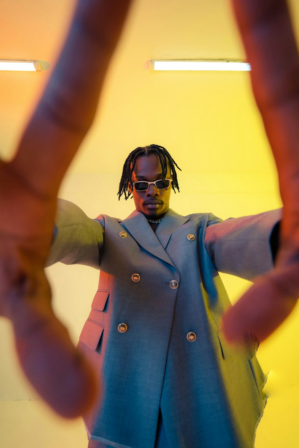 a man in a suit and sunglasses making a v sign