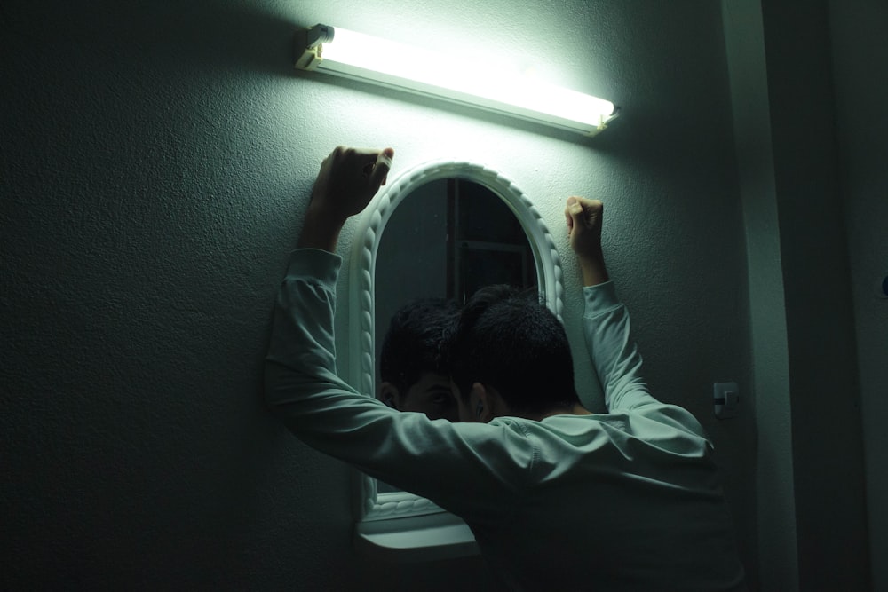 a man standing in front of a bathroom mirror