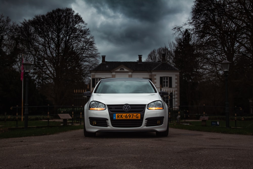 a white car parked in front of a house