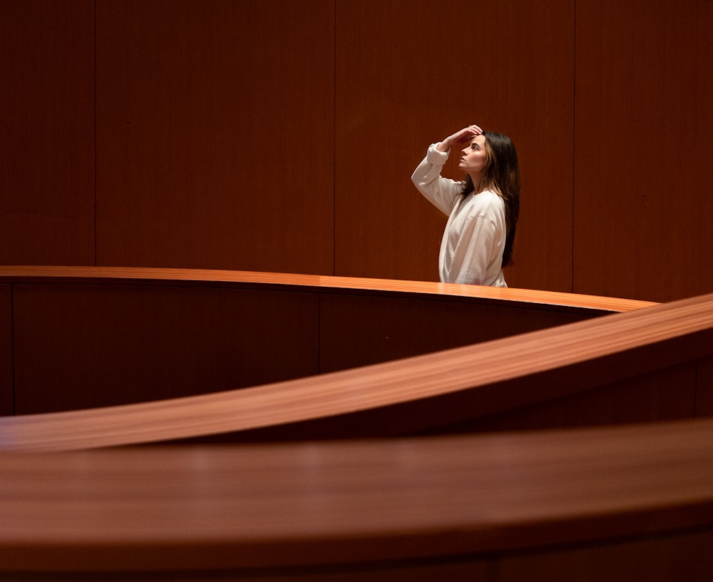 a woman standing in front of a wooden wall