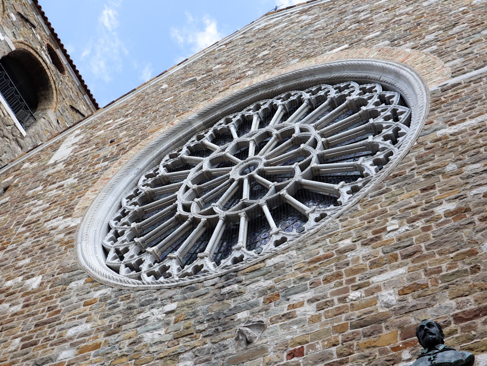 a large round window on the side of a brick building