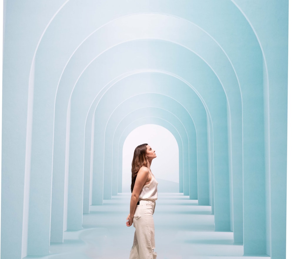 a woman standing in a tunnel of blue water