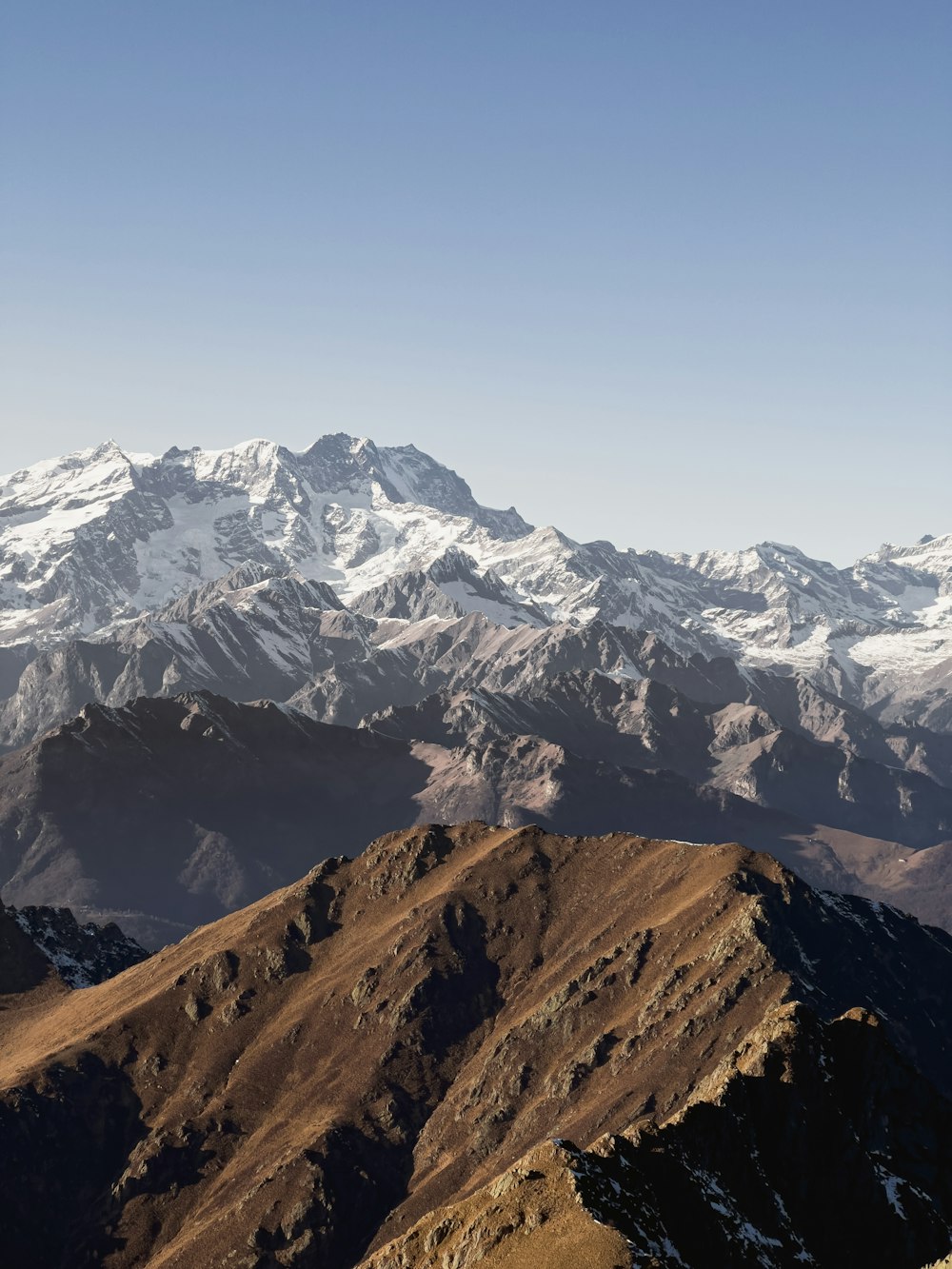 a mountain range with snow capped mountains in the background